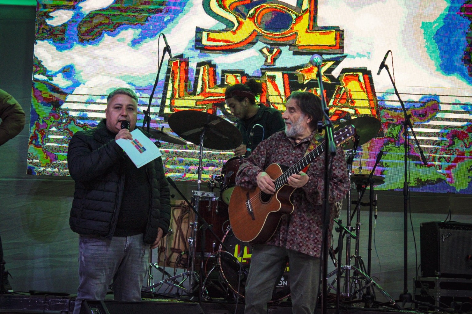 Presentación en el escenario junto a un músico con guitarra