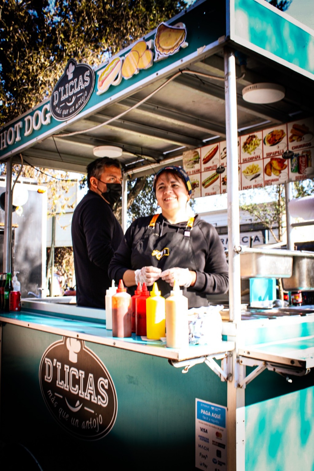 Puesto de comida y participantes de la feria